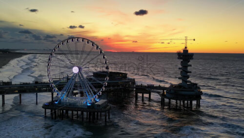 The Hague, Netherlands – November 21, 2024: Aerial drone view of the Scheveningen Pier and Ferris Wheel at the Dutch North Sea Coast - Starpik Stock