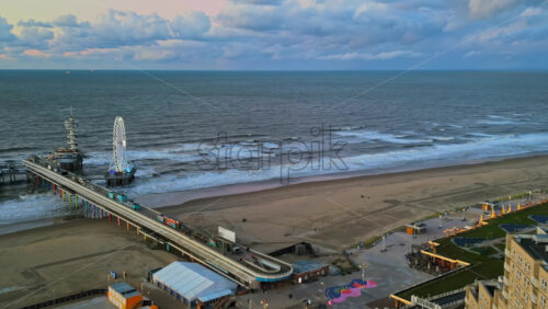 The Hague, Netherlands – November 21, 2024: Aerial drone view of the Scheveningen Pier and Ferris Wheel at the Dutch North Sea Coast - Starpik Stock