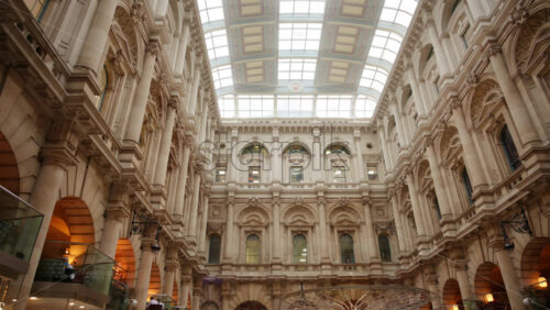 The Interior of the Royal Exchange building with arched windows and glass roof in London, England - Starpik Stock