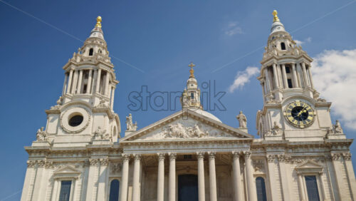 The St. Paul’s Cathedral rising above the trees with a clear blue sky in the background in London, England - Starpik Stock