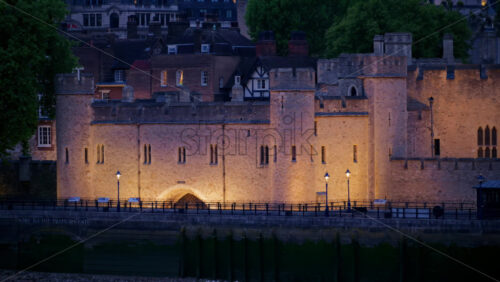 The Tower of London walls lit up warmly in the evening in England - Starpik Stock
