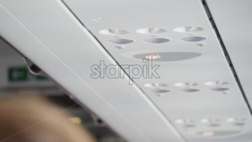 The panels above the airplane seats and the no smoking sign - Starpik Stock