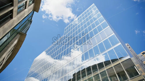 Timelapse of modern glass skyscrapers of London’s financial district reflecting the blue sky next to historic architecture - Starpik Stock