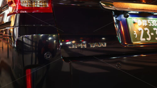 Tokyo, Japan – April 12, 2025: Close up of the logo of a black Toyota JPN Taxi car on the street in the evening - Starpik Stock
