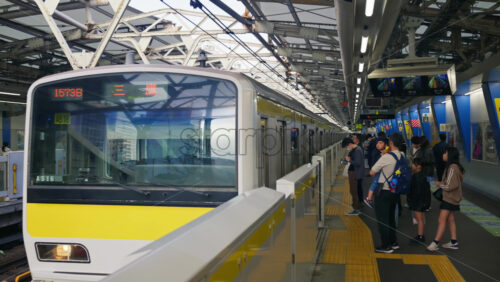 Tokyo, Japan – April 12, 2025: People waiting at the Suidobashi train station. Translation: “Chuo/Sobu line” - Starpik Stock