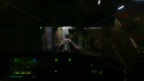 Tokyo, Japan – April 12, 2025: View from a moving train driver window of it arriving at the station in daylight - Starpik Stock