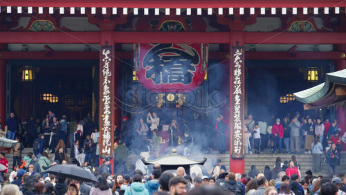 Tokyo, Japan – April 13, 2025: People walking under hanging paper lanterns at the Senso-ji temple in Asakusa. Translation: “Kobuna Town” - Starpik Stock