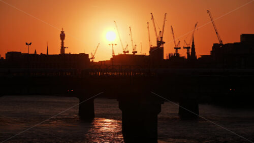 Train moving on Cannon Street Railway Bridge over the Thames River at sunset, London, England - Starpik Stock
