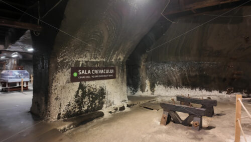 Turda, Romania – July 20, 2025: Large wooden extraction machinery displayed inside the Turda salt mine, with tourists walking around - Starpik Stock