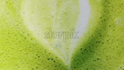 Video – Close up of a frothy matcha latte with heart-shaped latte art - Starpik Stock