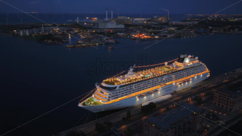 Video – Copenhagen, Denmark – August 3, 2025: Aerial drone view of the illuminated Crystal Serenity cruise ship docked at Copenhagen Cruise Terminal, Nordhavnen - Starpik Stock