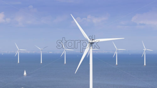 Video – Copenhagen, Denmark – August 4, 2025: Aerial drone view of offshore wind turbines spinning in the sea at the Oresund Wind Farm - Starpik Stock