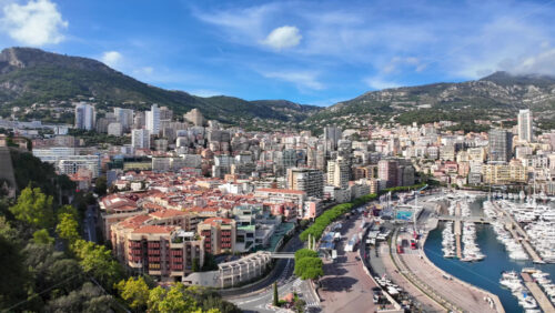 Video – High-angle view of Port de Fontvieille in Monaco, showcasing colorful buildings, luxury yachts, and the surrounding mountainous landscape - Starpik Stock
