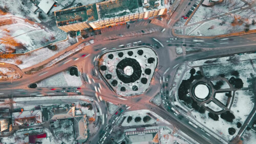 Video – Hyperlapse of a roundabout intersection, drone view. Roads with moving cars, bare trees, snow on the ground. Chisinau, Moldova - Starpik Stock