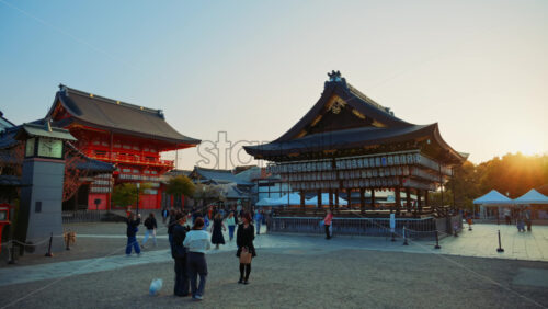 Video - Kyoto, Japan - April 11, 2025: People walking through the courtyard of the Yasaka shrine at sunset