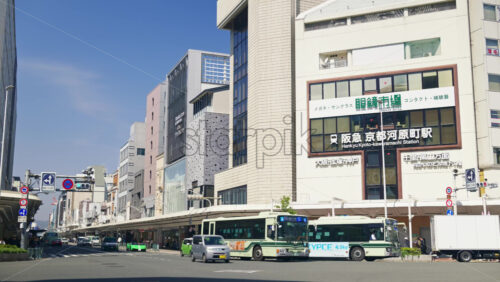 Video - Kyoto, Japan - April 12, 2025: Cars and public transportation moving on the streets of the Gion area in daylight. Translation: "Destinations from the train station"