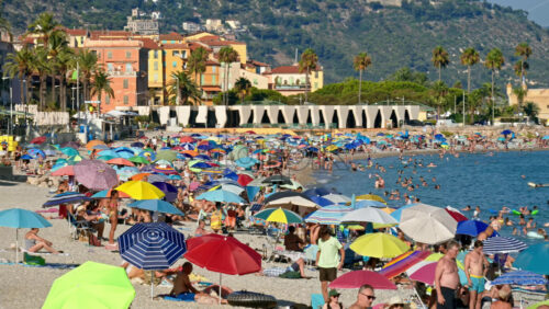 Video – Menton, France – September 4, 2024: People swimming and relaxing on the beach under sun umbrellas - Starpik Stock