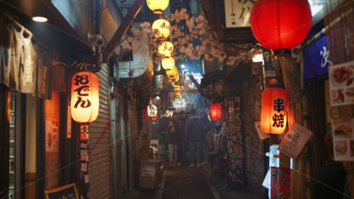 Video - Shinjuku, Japan - April 12, 2025: People walking on the Omoide Yokocho Memory Lane in the evening. Translation: "Oden, Kushiyaki"