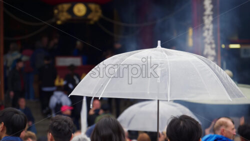 Video - Taito, Japan - April 13. 2025: Slow motion of people holding umbrellas walking through the Asakusa, Kannon Dori Market on a rainy day