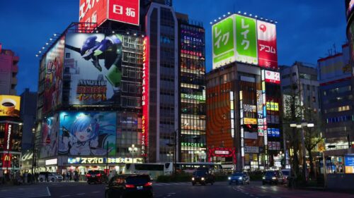 Video – Tokyo, Japan – April 12, 2025: View of the vibrant life of Shinjuku City with people and cars moving on the streets with lighted buildings in the evening. Translation: “Kabukicho impact” - Starpik Stock
