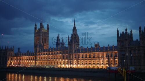 Video – View of the Palace of Westminster at night with its lights reflecting on the River Thames, London, England - Starpik Stock