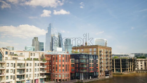 View of London’s skyline with glass skyscrapers and riverfront buildings along the Thames, London, England - Starpik Stock