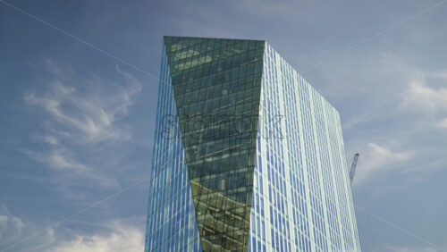 View of a modern glass office building in London, England with sunlight reflecting off windows - Starpik Stock