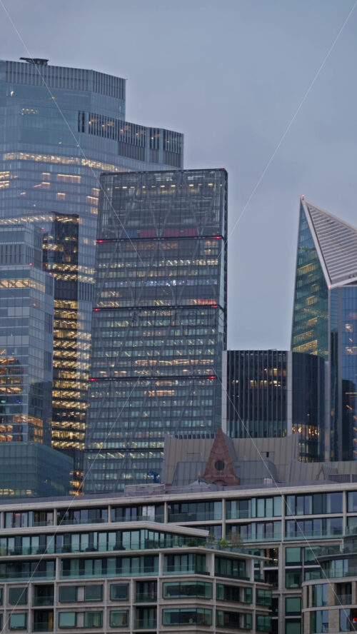 View of a modern glass office buildings in London, England in the evening. Vertical - Starpik Stock