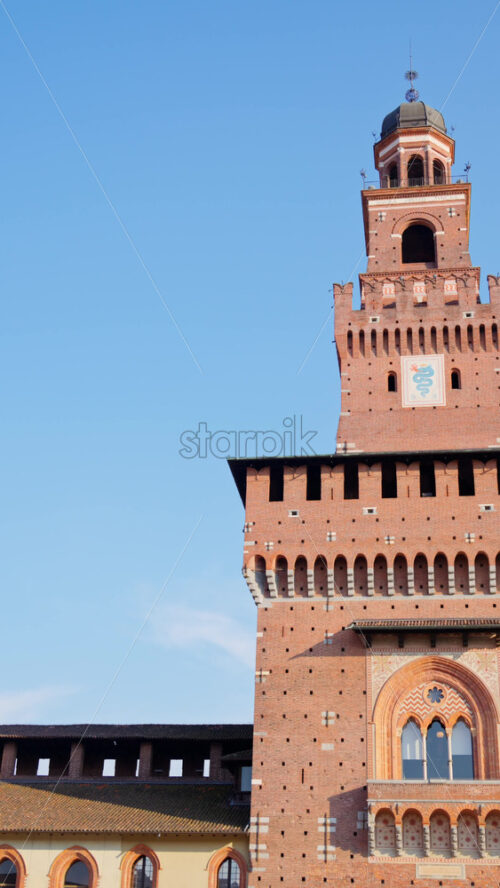 View of the Filarete Tower in Milan, Italy on the blue sky background. Vertical - Starpik Stock