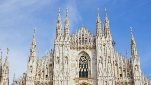 View of the Milan Cathedral in Italy over a blue sky in daylight - Starpik Stock