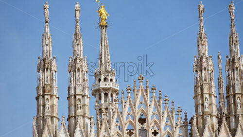 View of the Milan Cathedral in Italy over a cloudy sky in daylight - Starpik Stock