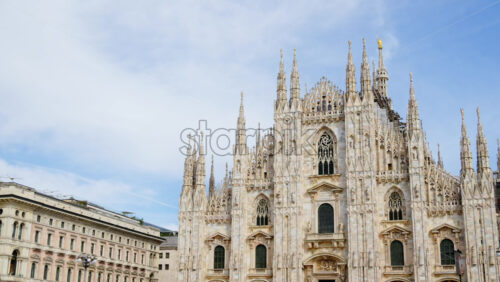 View of the Milan Cathedral in Italy over a cloudy sky in daylight - Starpik Stock