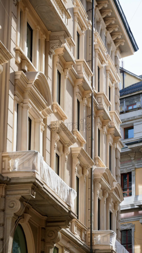 View of white buildings in the city in daylight in Milan, Italy. Vertical - Starpik Stock