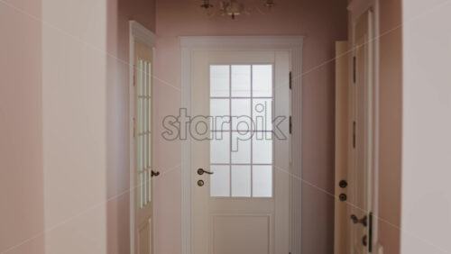 View of white doors in a home with pink walls - Starpik Stock