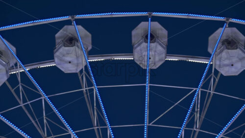 View of white, illuminated ferris wheel rotating in Antibes, France in the evening - Starpik Stock