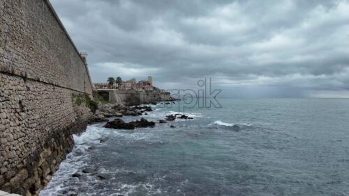 Waves crashing against the rocks along a rocky coastline - Starpik Stock