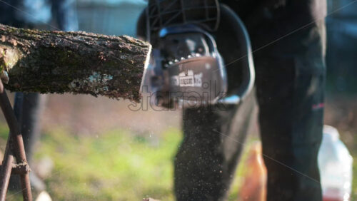 Video - Man in gloves is choping wood using a chainsaw. Close view