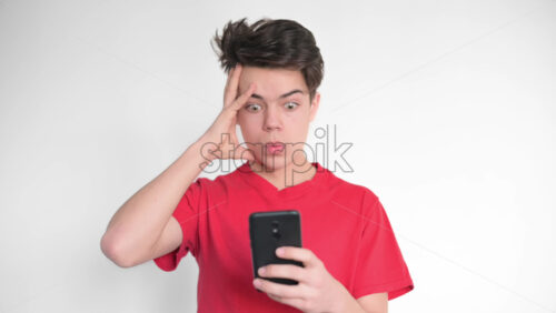 Video - Boy is on his smartphone and getting shocked. White background