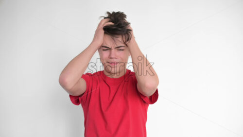 Video - Boy is getting desperate. Holding head. White background