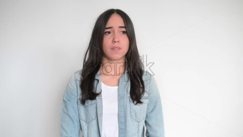 Video - Girl is getting sad. Crossing hands. White background