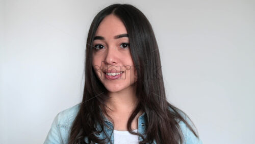 Video - Girl is showing a flacon. Smiling. White background