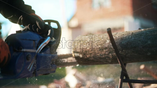 Video - Man in gloves is choping wood using a chainsaw. Close view