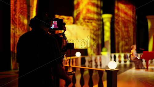Video - Man filming with professional camera on the backstage of a TV set
