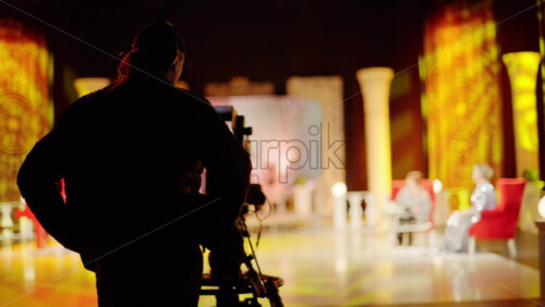 Video - Man filming with professional camera on the backstage of a TV set