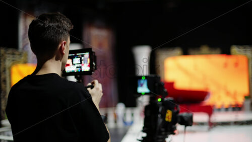 Video - Man filming with professional camera on the backstage of a TV set