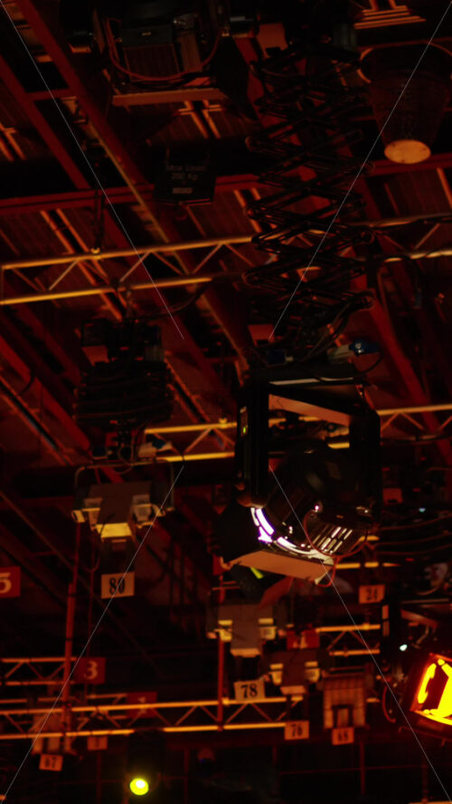 Video - Flashing studio lights equipment on the ceiling of a TV set. Vertical