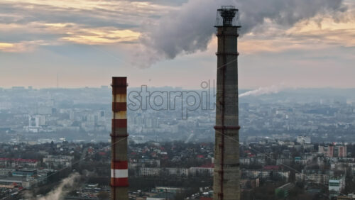 Video - Aerial drone view of a working thermal power station in Chisinau at sunset. Steam and smoke coming from pipes. Moldova