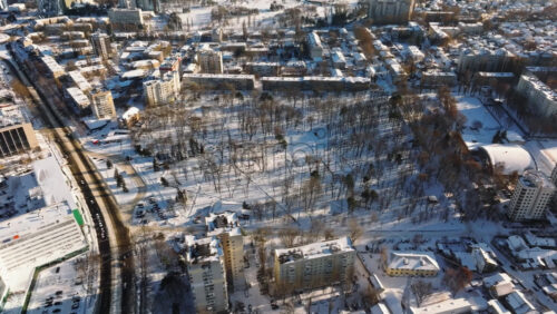 Video - Aerial drone view of the city park covered in snow. Sunrise during winter in Chisinau, Moldova