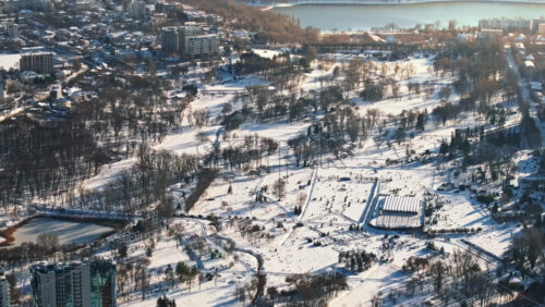 Video - Aerial drone view of the city park covered in snow. Sunrise during winter in Chisinau, Moldova