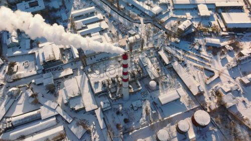 Video - Aerial drone view of a working thermal power station in Chisinau city covered in snow. Steam and smoke coming from pipes. Moldova